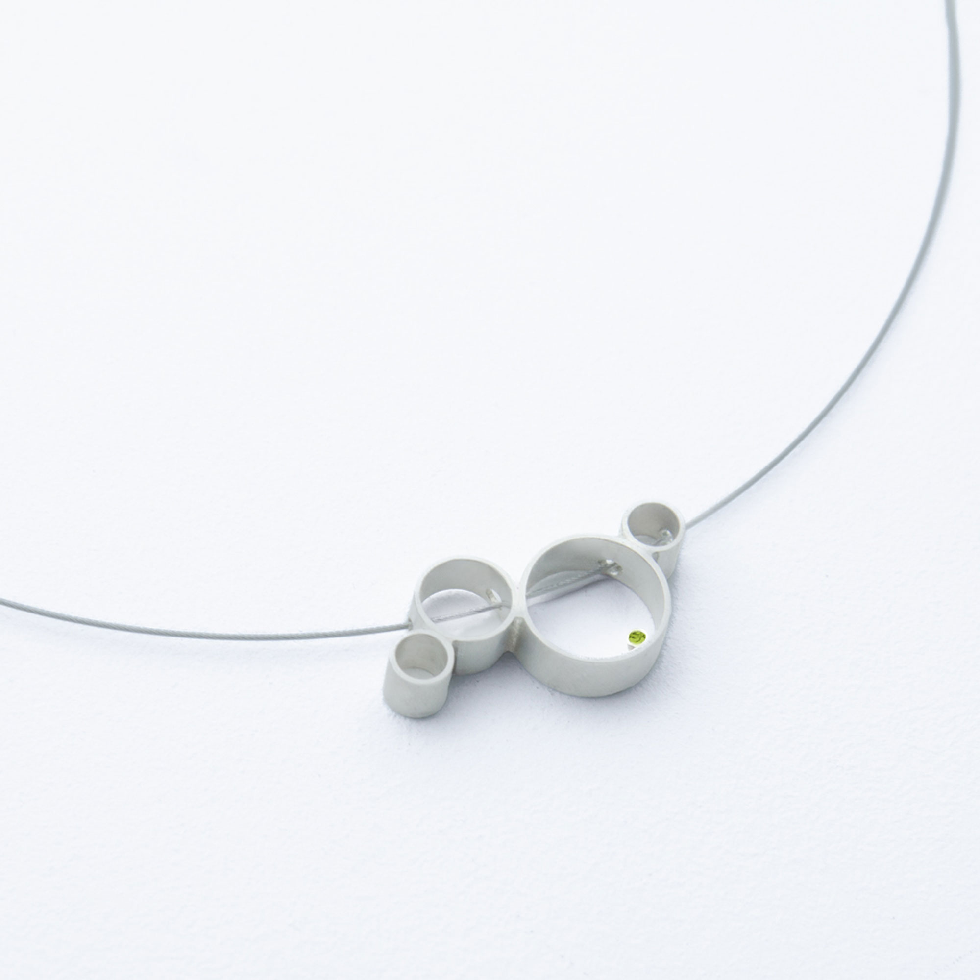 Handgemachter Schmuck von Studio 4L. Kollier Circles Silber mit handgefasstem 1,5mm mm Peridot